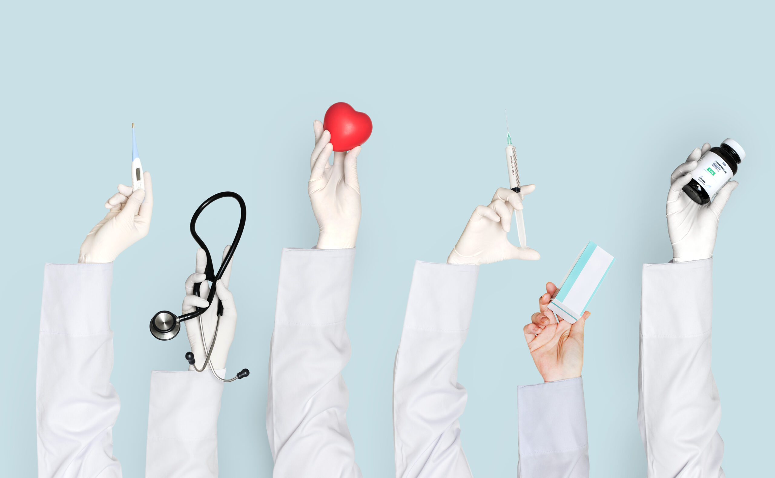 Doctors hands holding medical care objects